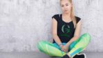 Fitness, dieting and sport concept. Healthy active female sits crossed legs, wear sneakers and sport clothing, Товары для йоги, Yoga goods